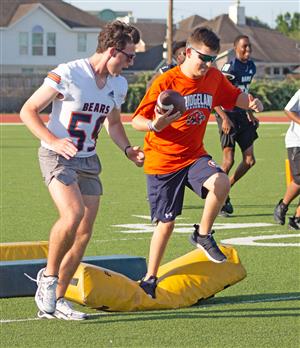 a Bridgeland HS football player encourages a BHS life skills student at Camp Courage.